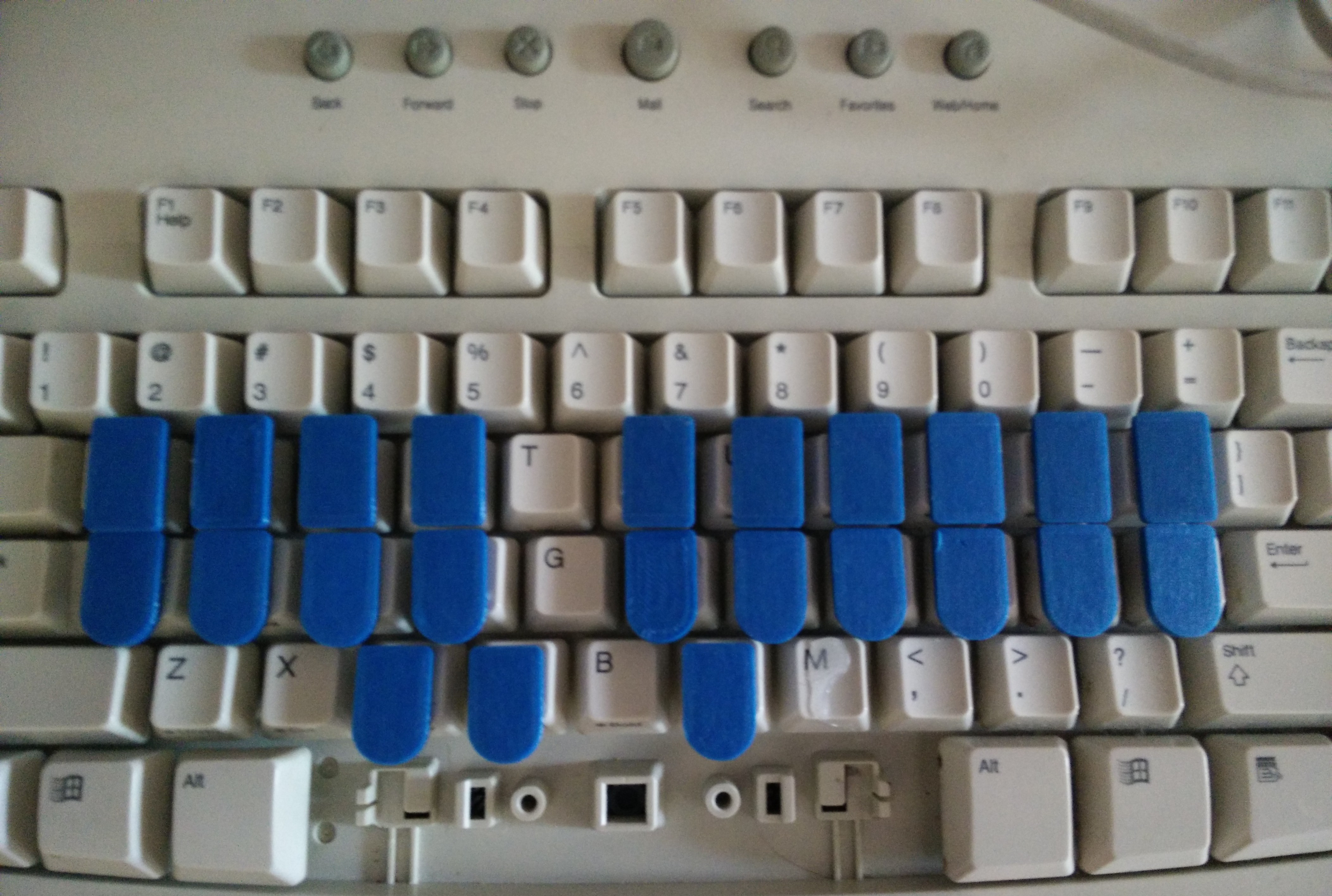 3D printed key toppers glued on a keyboard.